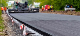Asphalt paver on the road during asphalt laying in defocus. Road repair. Laying a new road